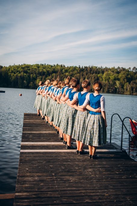 Dirndl im Vereinsdirndlgwand stehen zusammen auf dem Steg des Tütensees